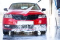 Car washing. Cleaning car using high pressure water Royalty Free Stock Photo