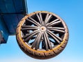 A car wheel attached to the roof of a building against the blue sky.