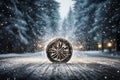 a car wheel on the background of a winter road and a beautiful night landscape, a snow-covered forest with lights, a concept Royalty Free Stock Photo