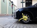 Car wheel blocked by wheel lock because illegal parking violation Wheel lock for anti-theft with the car on the road or concrete