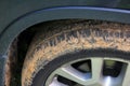 Car wheel caked in red dirt closeup