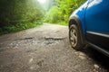 Car wheel and cracked damaged road