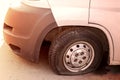 Car wheel flat tire on the road. Small white truck with punctured wheel