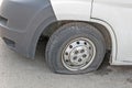 Car wheel flat tire on the road. Small white truck with punctured wheel