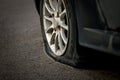 Car wheel with a flat tire on the roadway. Image of an accident, damage, breakdown for illustration on the topic of repair, Royalty Free Stock Photo