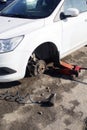 Car without wheel and lift up by hydraulic, waiting for tire replacement