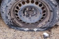 Car wheel with old flat tire on wet concrete surface Royalty Free Stock Photo