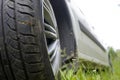 Car wheel on a car in summmer green grass Royalty Free Stock Photo