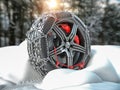 Car wheel with winter tire and snow chain in snow forest Royalty Free Stock Photo