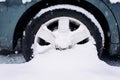 Car wheel with winter tires in the snow. Wheel stuck in a snowdrift. Snow drifts on road, bad weather Royalty Free Stock Photo
