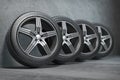 Car wheels. Four new black tyres with alloy discs in garage Royalty Free Stock Photo