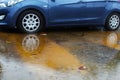 Car wheels in a puddle of rainwater, raindrops and water circles. Winter weather in Israel