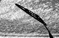 Car whiper blade and snow on glass with blur effect in black and white Royalty Free Stock Photo