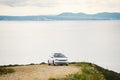 A car of white color, the station wagon travels along a dirt road, stony roads along the coastline in the mountains near the coast Royalty Free Stock Photo