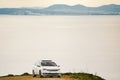 A car of white color, the station wagon travels along a dirt road, stony roads along the coastline in the mountains near the coast Royalty Free Stock Photo
