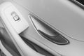 Car white leather interior details of door handle with windows controls and adjustments. Car window controls of modern car. Car de