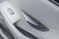 Car white leather interior details of door handle with windows controls and adjustments. Car window controls of modern car Royalty Free Stock Photo