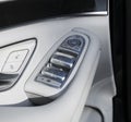 Car white leather interior details of door handle with windows controls and adjustments. Car window controls of modern car Royalty Free Stock Photo