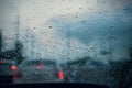 Car window with rain drops on glass or the windshield,Blurred traffic on rainy day