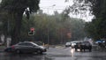 Car windshield view of rain city traffic. Cars move by crossroad while drizzle rain