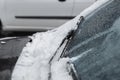 Car windshield with wiper blades cleaned from snow outdoors on winter day