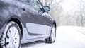 Car on the Winter Road. Close-up Image of Winter Car Tire on the Snowy Road. Safe Driving Concept.