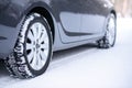 Car on the Winter Road. Close-up Image of Winter Car Tire on the Snowy Road. Safe Driving Concept.