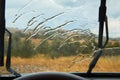 Car wiper cleaning rain drop on windshield. Driving in rain. Nature through window. Rainy weather and auto trip concept