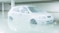 car wrapped in plastic floats in flooded garage, creating surreal scene