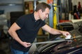 Car wrapper straightening foil with a squeegee Royalty Free Stock Photo