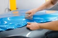Car Wrapping, Mechanic With Squeegee Installs Film