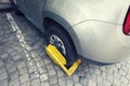 Car with yellow clamp on a wheel parked in a city parking Royalty Free Stock Photo