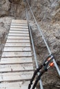 Carabiner clipped onto the cable of a via ferrata with bridge in Sexten Dolomites mountains, South Tyrol