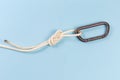 Carabiner in rope knot ÃÂ°igure-eight loop on blue background