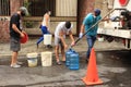 People fill containers with water from truck tanker delivery by major municipalities hydrant during COVID-19 quarantine