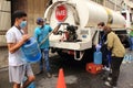 People fill containers with water from truck tanker delivery by major municipalities hydrant during COVID-19 quarantine