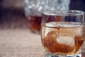 Carafe and glass of whisky, whiskey bourbon on a burlap, sacks background Royalty Free Stock Photo