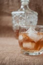 Carafe and glass of whisky, whiskey bourbon on a burlap, sacks background Royalty Free Stock Photo