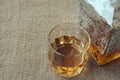 Carafe and glass of whisky, whiskey bourbon on a burlap, sacks background Royalty Free Stock Photo
