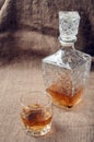 Carafe and glass of whisky, whiskey bourbon on a burlap, sacks background Royalty Free Stock Photo