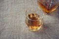 Carafe and glass of whisky, whiskey bourbon on a burlap, sacks background Royalty Free Stock Photo