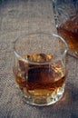 Carafe and glass of whisky, whiskey bourbon on a burlap, sacks background Royalty Free Stock Photo