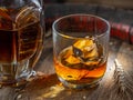 Carafe of whisky and glass of whisky on old wooden cask at the dark background Royalty Free Stock Photo