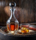 Carafe of whisky and glass of whisky on old wooden cask at the dark background Royalty Free Stock Photo
