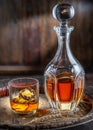 Carafe of whisky and glass of whisky on old wooden cask at the dark background Royalty Free Stock Photo