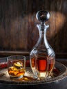 Carafe of whisky and glass of whisky on old wooden cask at the dark background Royalty Free Stock Photo