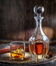 Carafe of whisky and glass of whisky on old wooden cask at the dark background Royalty Free Stock Photo