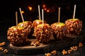 Caramel apples with Walnuts on a stick for halloween on wooden table