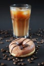 Caramel donut with coffee decor next to a glass of frappuccino with ice