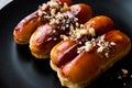 Caramel Eclairs with Hazelnut and cream in black plate.